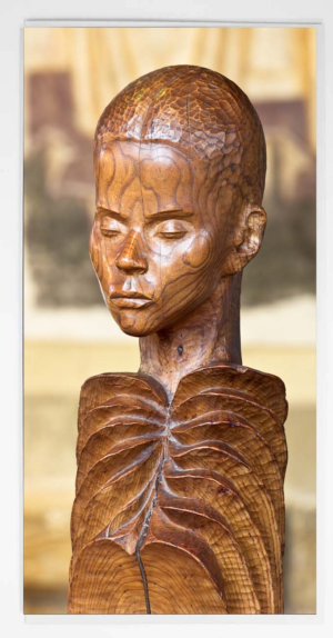 Carved wooden statue of a serene figure with closed eyes and prominent ribbed chest detail in warm wood tones. Durham Cathedral Annunciation Greeting Card, Durham Cathedral Stainded Glass Window, Interior Photograph of Durham Cathedral, Durham Cathedral Gift Product, Durham Cathedral Souvenir, North East Gift, Local Artist, Local Photographer, Durham Photograph